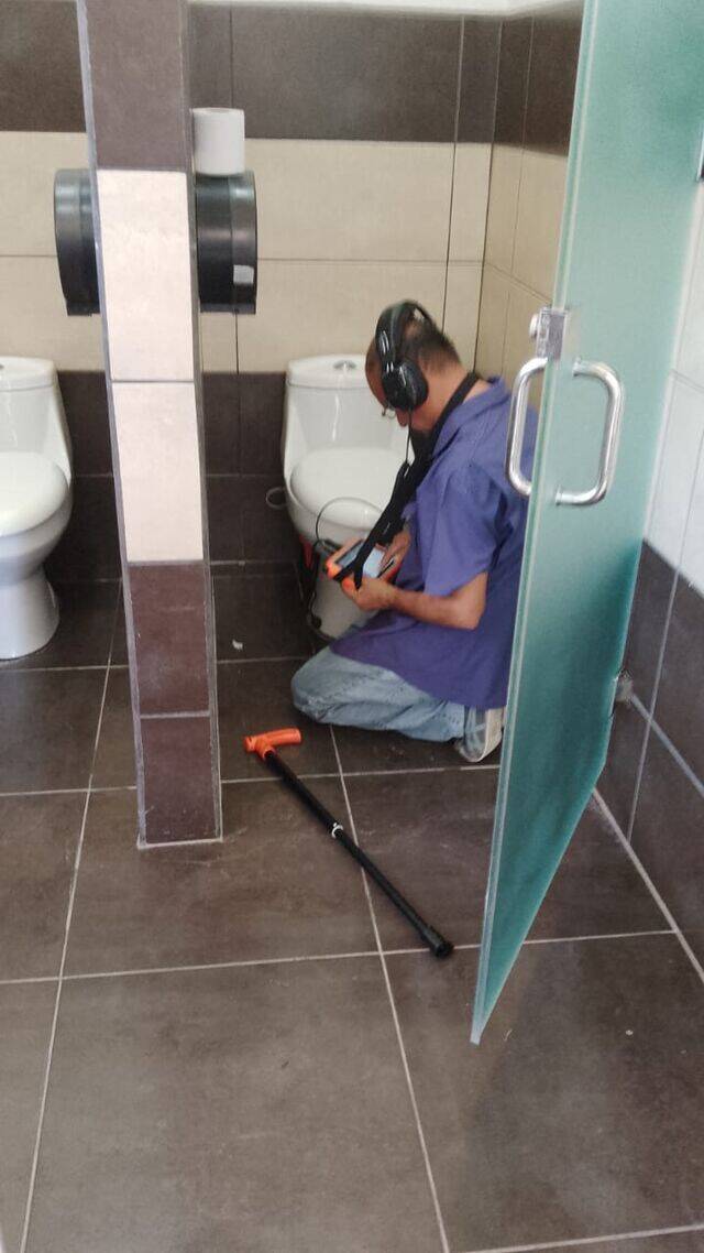 Técnico de Cerofugas usando equipo de detección de fugas de agua en un baño